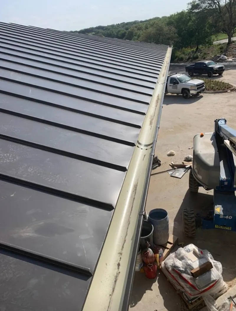 Standing seam panel and gutter detail on a metal roofing jobsite in Wyndham